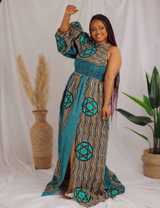 African print maxi dress with uneven bubble sleeve design, fitted and gathered fit and side pockets. The model is wearing a size 14.